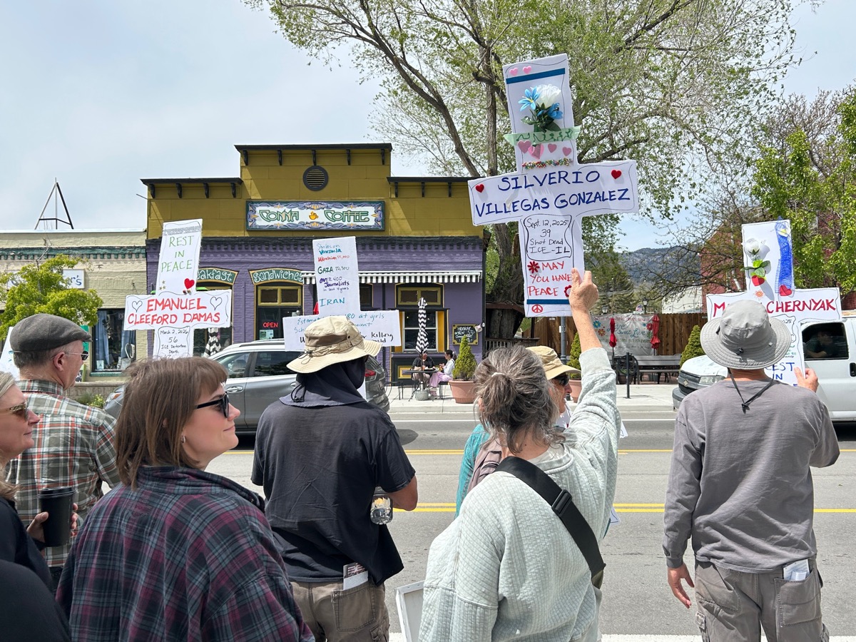 Crowd holding memorial signs for ICE detention victims