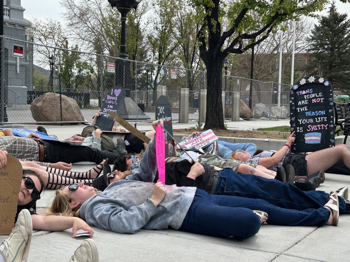 Ground-level view of die-in protest with signs